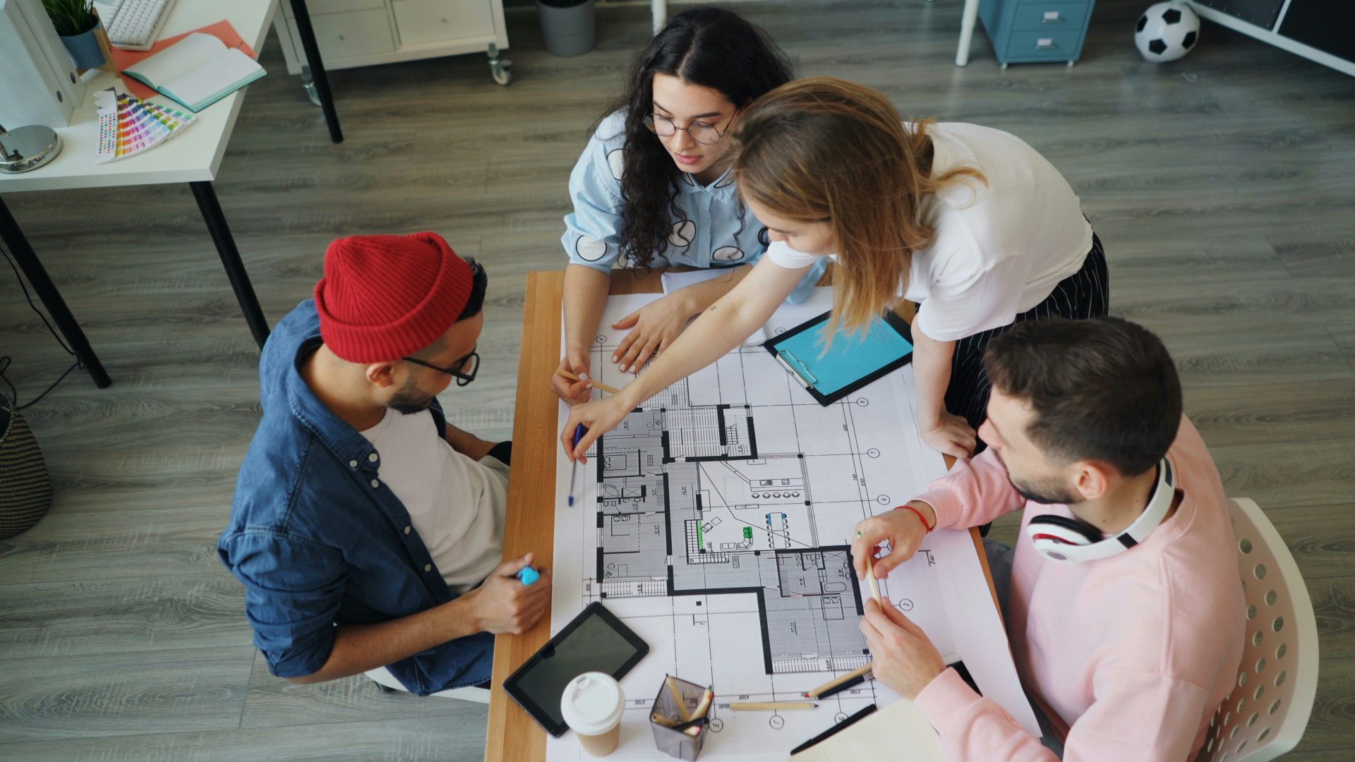 a group of people sitting around a table working on a project